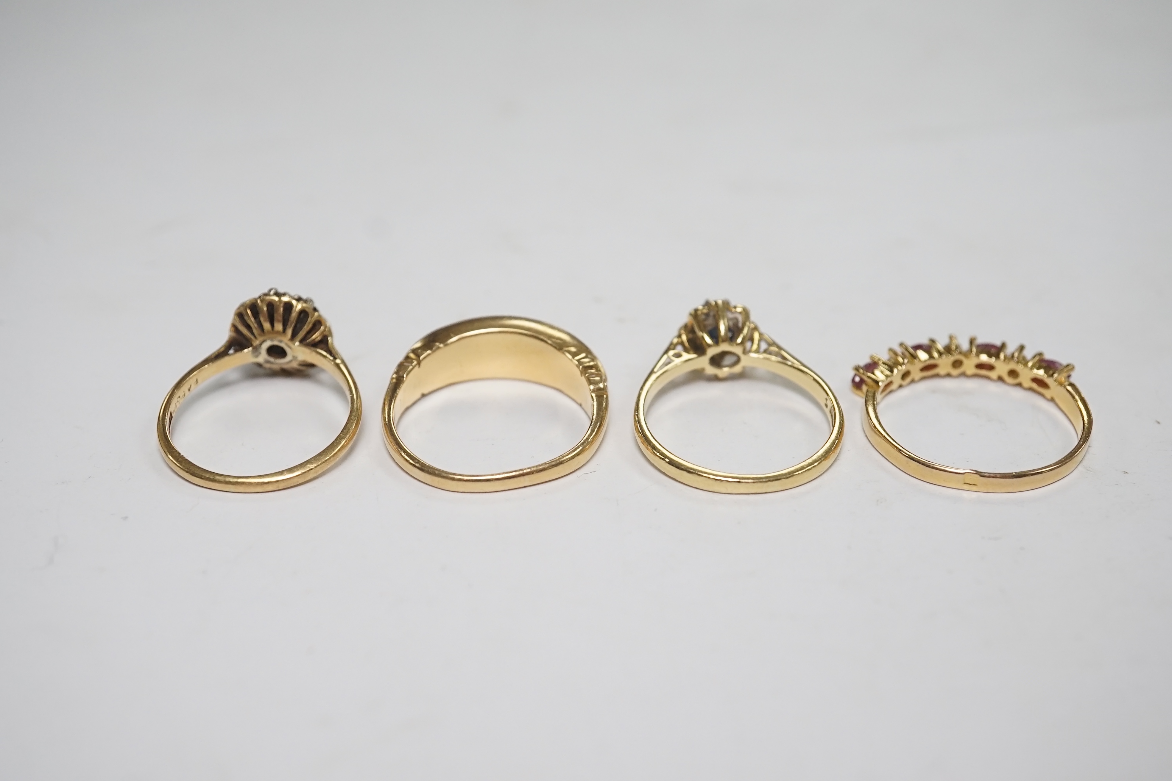 A late Victorian yellow metal and five stone split pearl set half hoop ring, with diamond chip spacers, size N/O, two modern 18ct gold and gem set rings and one other ring. Condition - fair to good